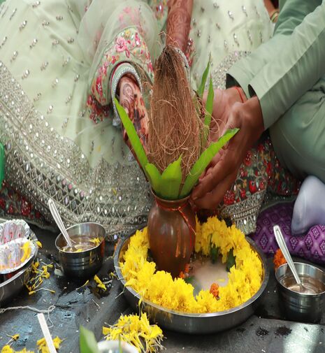 A wedding couple holding a coconut in their hands for traditional ritual
